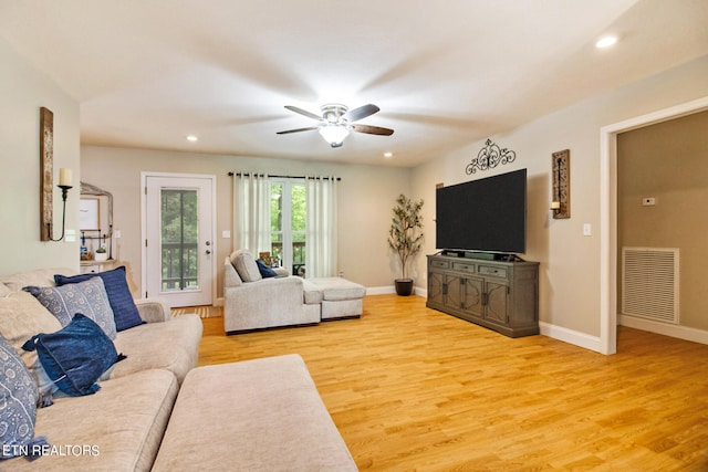 living room with light hardwood / wood-style flooring and ceiling fan