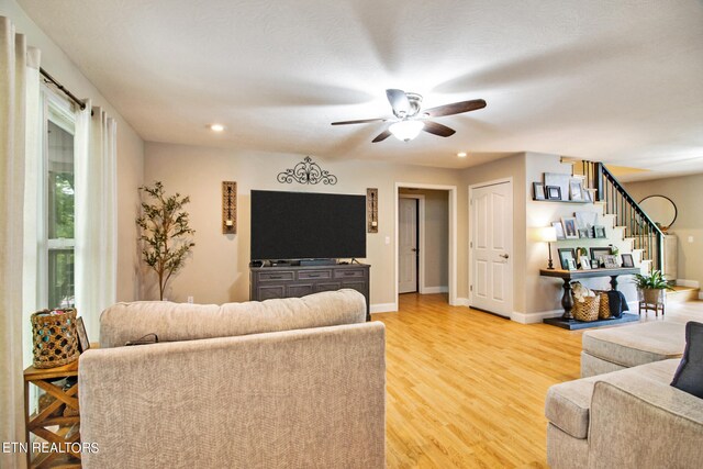 living room featuring ceiling fan and light hardwood / wood-style floors