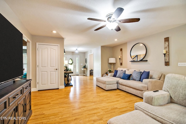 living room featuring light hardwood / wood-style flooring and ceiling fan