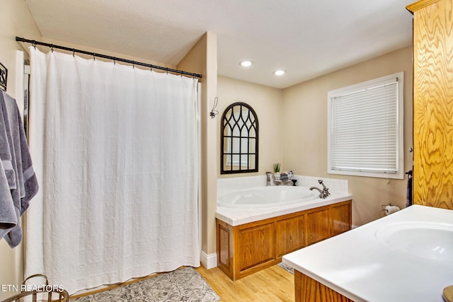 bathroom featuring wood-type flooring, vanity, and a bathtub