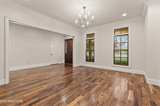 empty room featuring dark hardwood / wood-style floors, a chandelier, and crown molding