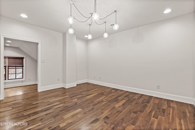 unfurnished room with dark hardwood / wood-style floors, a chandelier, and vaulted ceiling