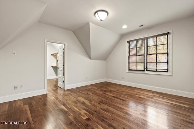 additional living space featuring dark hardwood / wood-style floors and vaulted ceiling