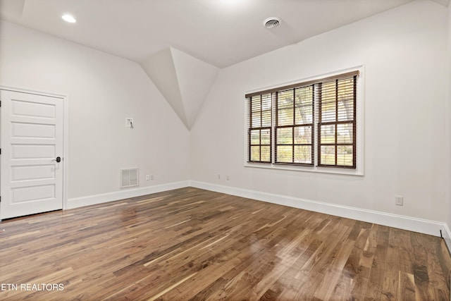 unfurnished room featuring hardwood / wood-style floors and lofted ceiling