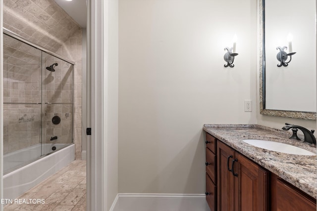 bathroom with bath / shower combo with glass door and vanity