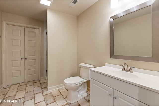 bathroom featuring walk in shower, vanity, and toilet