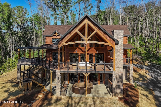 back of house with an outdoor living space and a patio