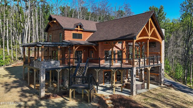 view of front of house featuring a wooden deck and a patio