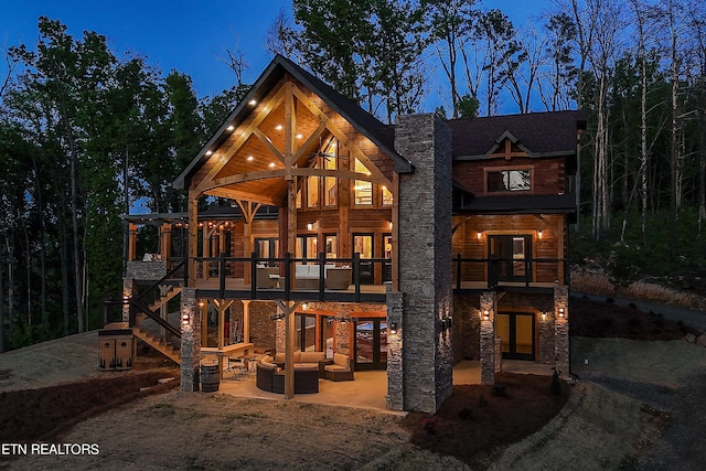 view of front of house with a balcony, outdoor lounge area, and a patio
