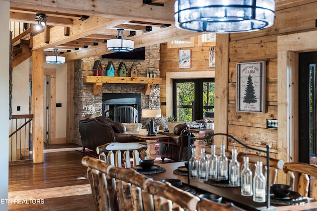 dining room featuring hardwood / wood-style flooring, a fireplace, wood walls, and french doors
