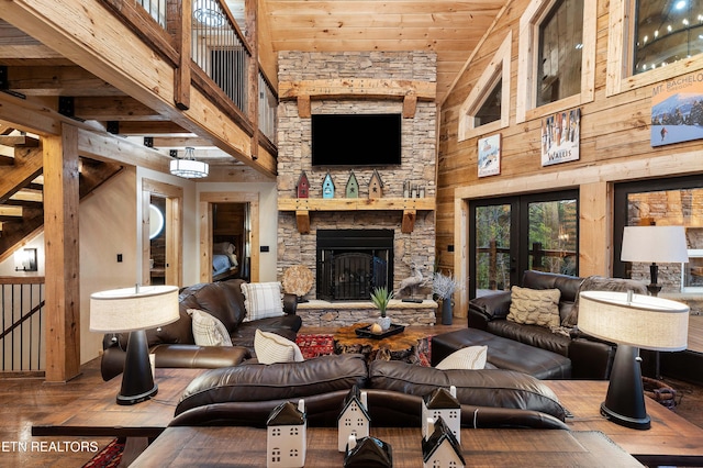 living room featuring wooden walls, wooden ceiling, a fireplace, french doors, and high vaulted ceiling