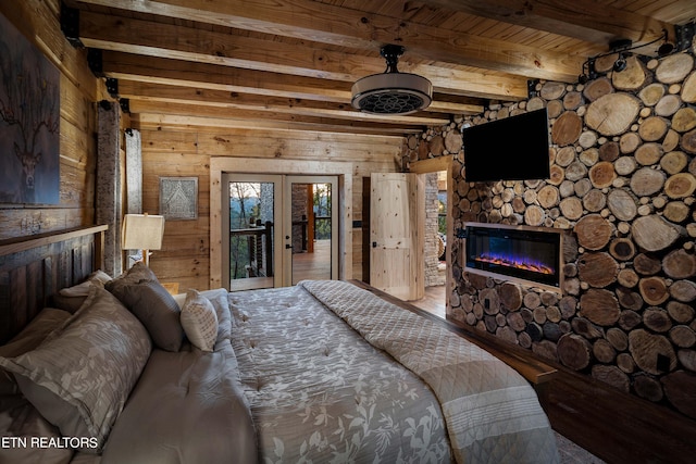 bedroom featuring wood ceiling, wooden walls, beamed ceiling, and a fireplace