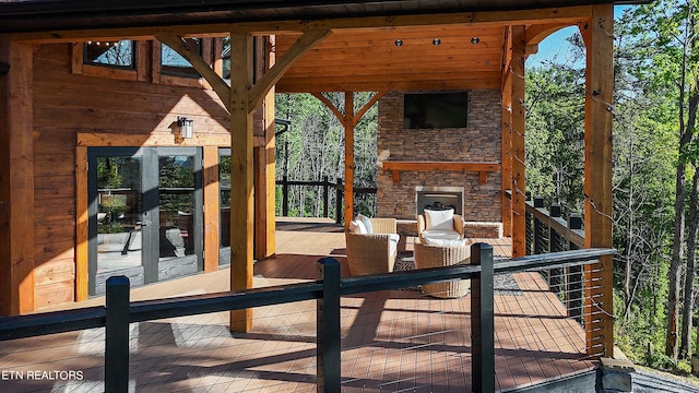 exterior space featuring a deck, french doors, and an outdoor living space with a fireplace