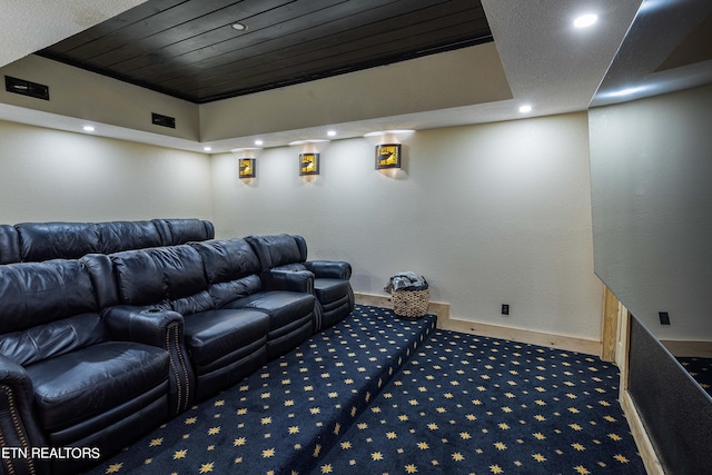 cinema room with carpet floors and a tray ceiling