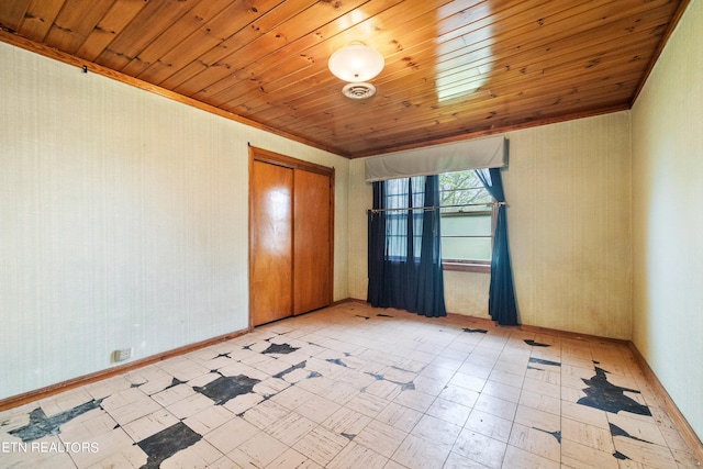 empty room featuring light tile floors and wood ceiling