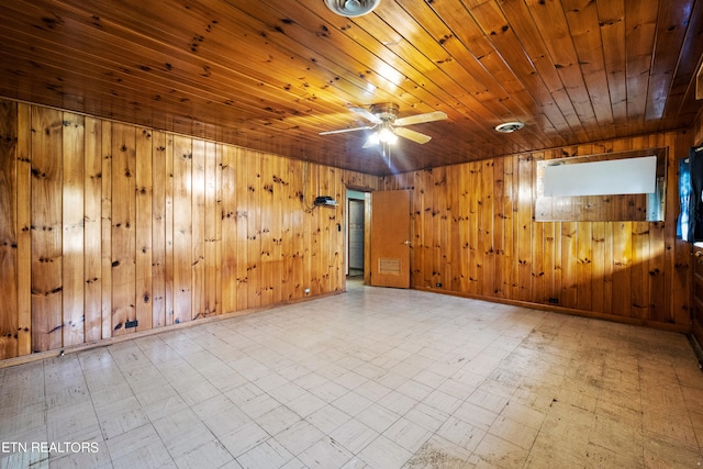 tiled spare room with wood ceiling, wooden walls, and ceiling fan