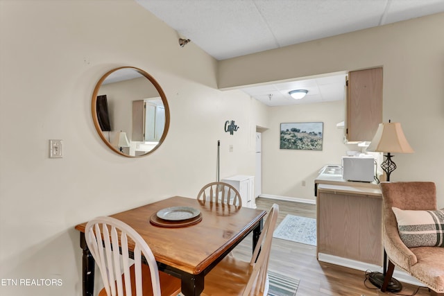 dining room featuring a drop ceiling and hardwood / wood-style flooring