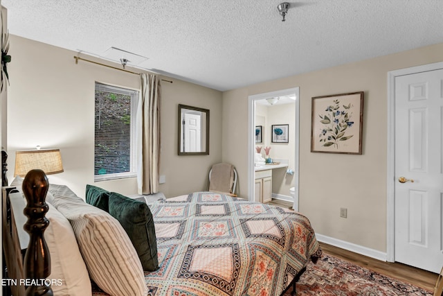 bedroom with connected bathroom, hardwood / wood-style flooring, and a textured ceiling