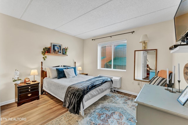 bedroom featuring wood-type flooring and a textured ceiling