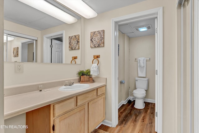 bathroom featuring wood-type flooring, toilet, and vanity