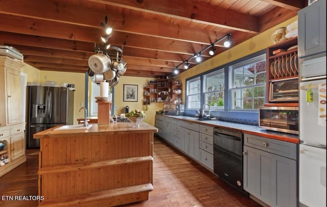 kitchen with appliances with stainless steel finishes, gray cabinets, beam ceiling, rail lighting, and wooden ceiling