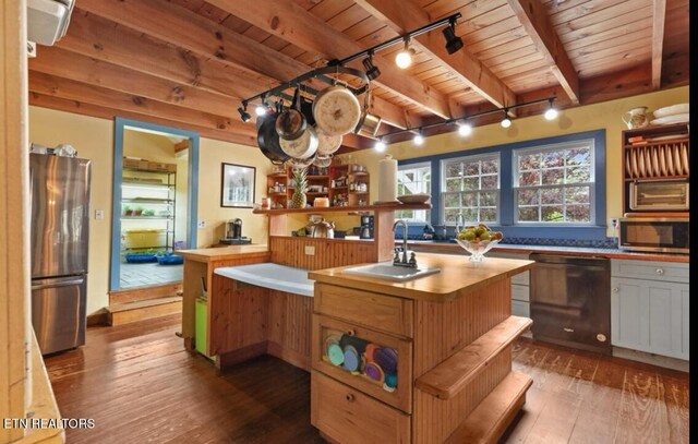 kitchen featuring appliances with stainless steel finishes, wood-type flooring, wood ceiling, sink, and a center island