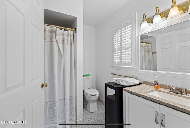 bathroom with vanity, toilet, and tile flooring