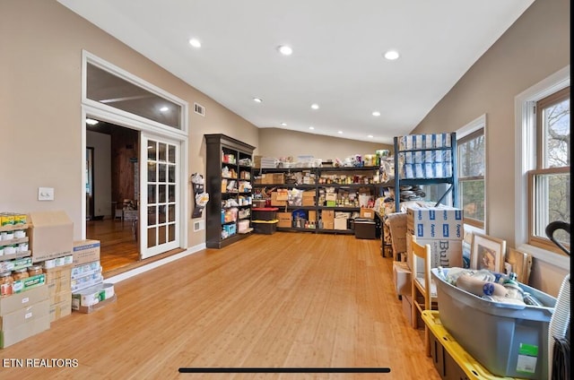 office with light hardwood / wood-style flooring and french doors