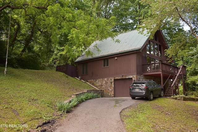 view of home's exterior featuring a wooden deck, a yard, and a garage