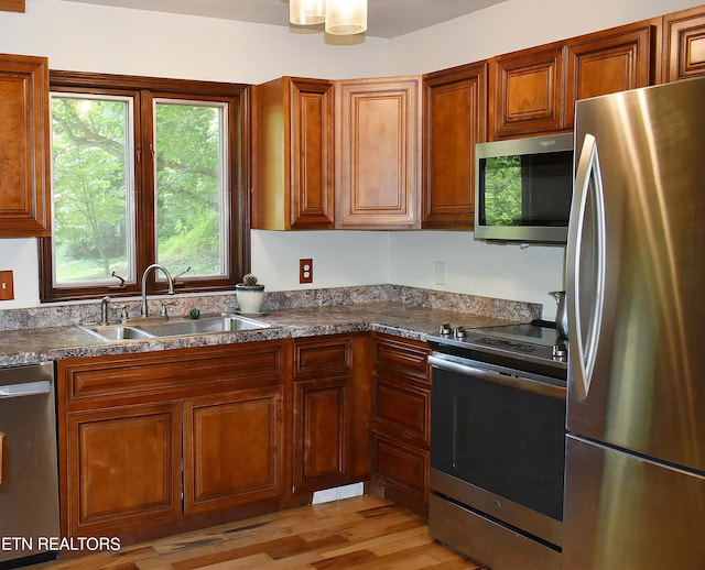 kitchen featuring sink, appliances with stainless steel finishes, and light hardwood / wood-style flooring