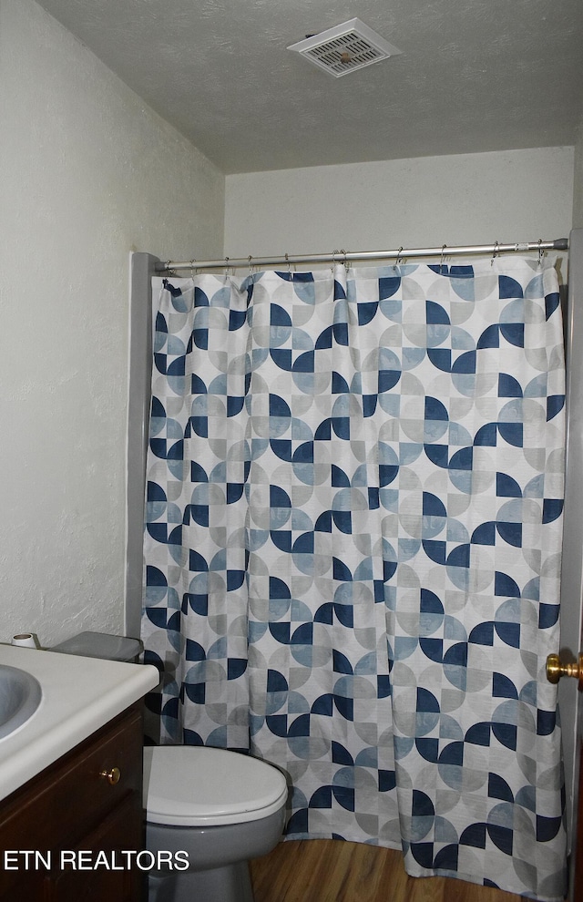 bathroom with wood-type flooring, vanity, and toilet