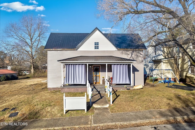 view of front of property featuring covered porch, a front yard, and a playground