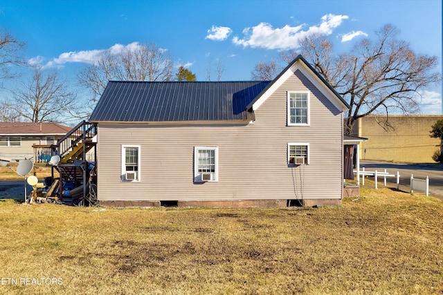 rear view of house featuring a lawn and cooling unit