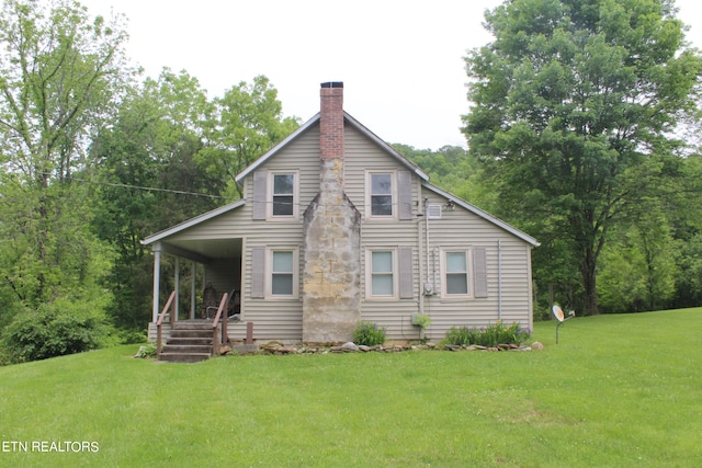 rear view of house featuring a lawn