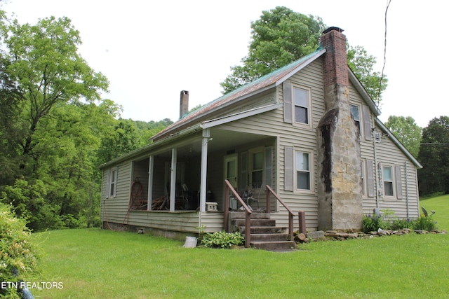 back of property featuring a lawn