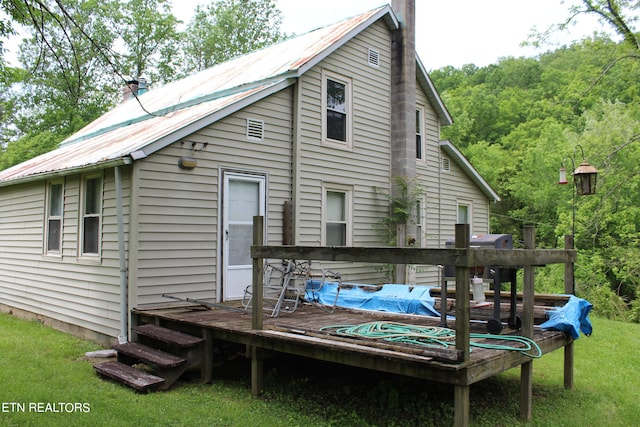 rear view of property with a yard and a deck