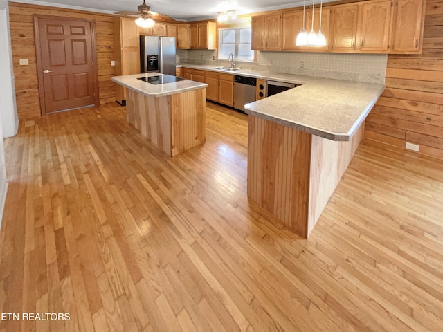 kitchen with light hardwood / wood-style floors, stainless steel appliances, hanging light fixtures, ceiling fan, and sink