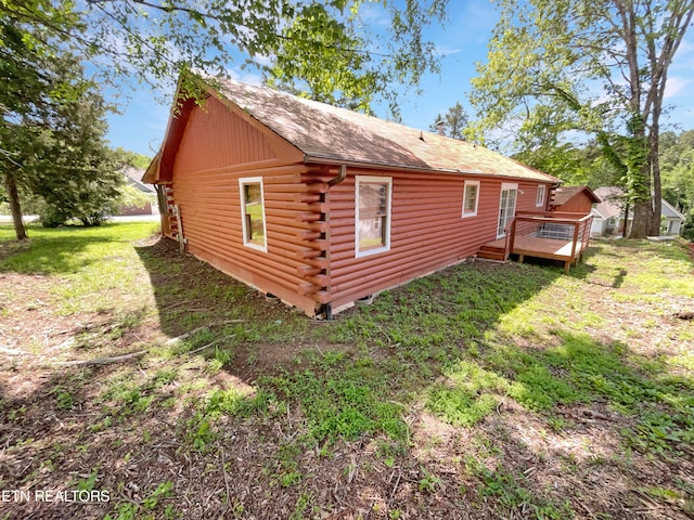 view of side of home featuring a deck and a yard