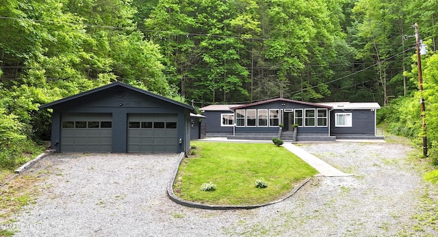 view of front facade with an outdoor structure, a garage, and a front lawn