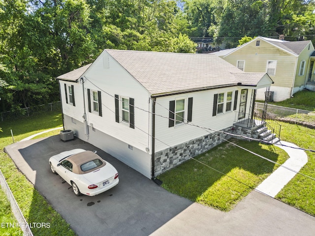 view of front facade with a front yard and central air condition unit