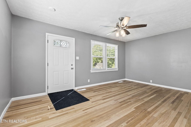 entryway featuring a textured ceiling, ceiling fan, and light wood-type flooring