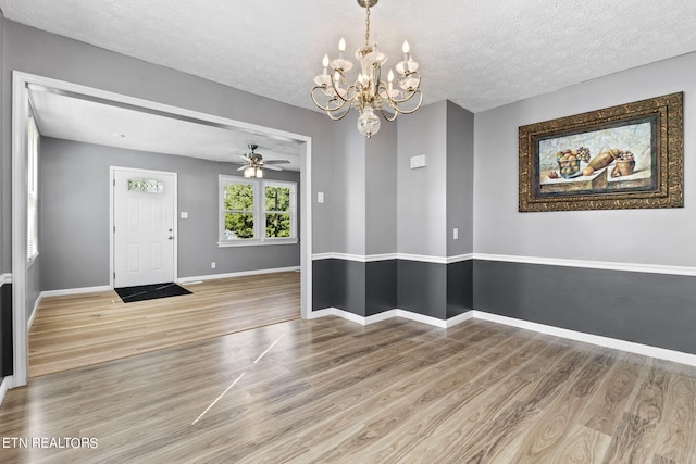 entryway featuring a textured ceiling, ceiling fan with notable chandelier, and hardwood / wood-style floors