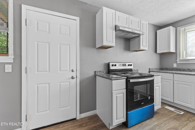 kitchen featuring a textured ceiling, white cabinets, light wood-type flooring, and range with electric cooktop