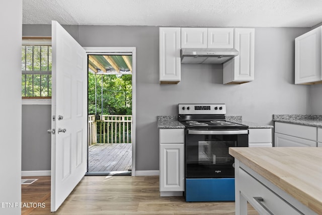 kitchen featuring butcher block counters, stainless steel electric stove, white cabinetry, light wood-type flooring, and a textured ceiling