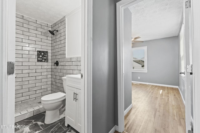 bathroom with hardwood / wood-style floors, vanity, toilet, and a textured ceiling