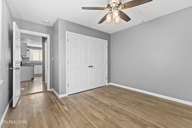 unfurnished bedroom featuring a closet, hardwood / wood-style flooring, and a textured ceiling