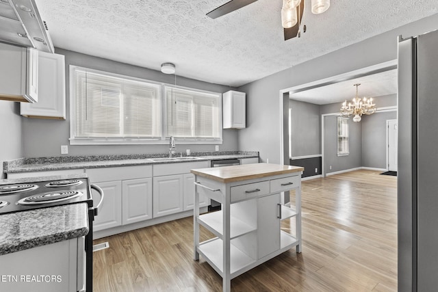 kitchen with sink, light hardwood / wood-style flooring, and white cabinetry