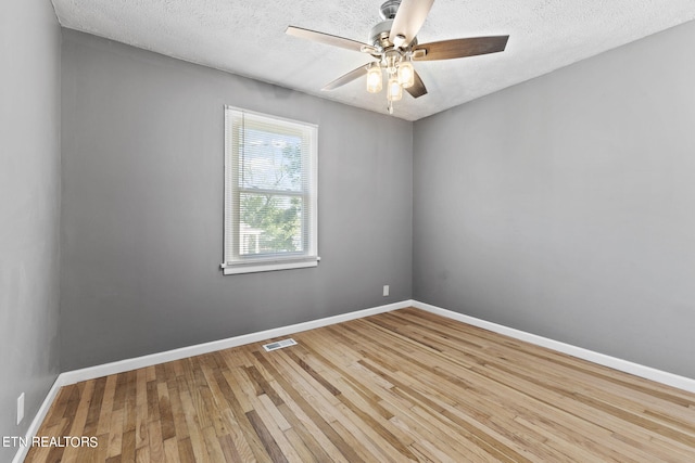 spare room featuring ceiling fan, light hardwood / wood-style flooring, and a textured ceiling