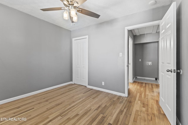 unfurnished bedroom featuring ceiling fan, light hardwood / wood-style flooring, and a textured ceiling