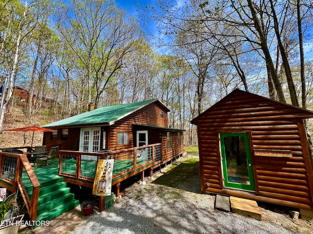 view of front of home with french doors, an outdoor structure, and a wooden deck